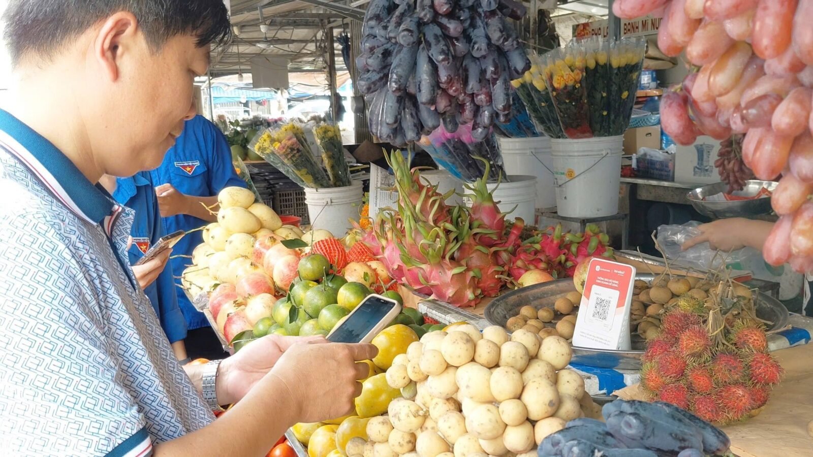 Sạp trái cây tại chợ truyền thống với mã QR Tendoo đặt trên quầy hàng