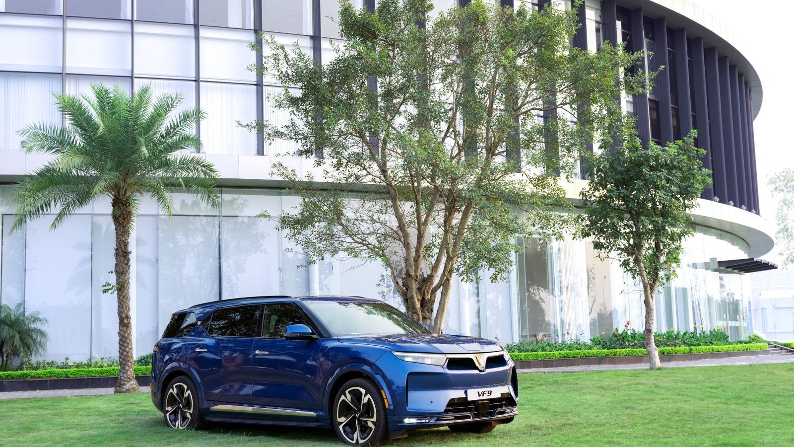 VinFast VF 9 màu xanh dương trong khuôn viên tòa nhà kính, mẫu SUV điện cỡ lớn gắn với quý doanh thu tăng 85,5% của VinFast